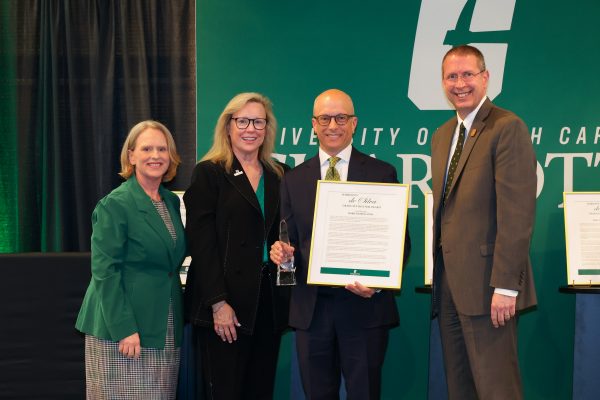 Professor Mark D'Amico receives the Harshini V. De Silva Award from Chancellor Sharon Gaber, Provost Jennifer Troyer, and Dean of the Graduate School Bill Tolone